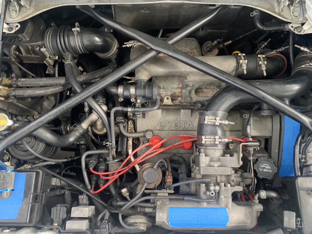 An engine bay in a car before being dry ice blast detailed.